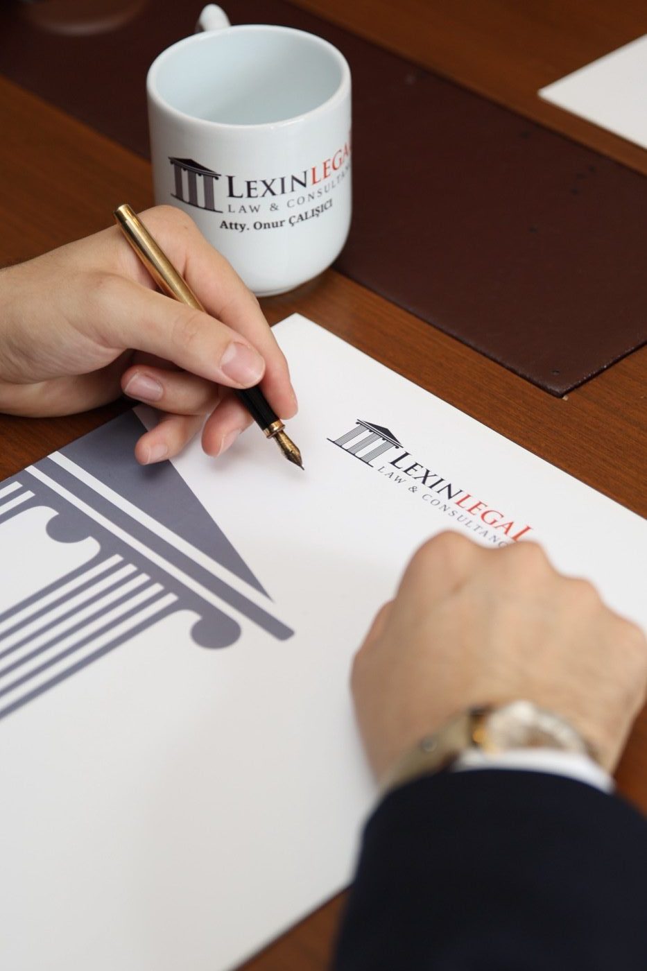 محامٍ من Lexin Legal يوقّع مستنداً على ورق المكتب الرسمي الحامل لعلامته
